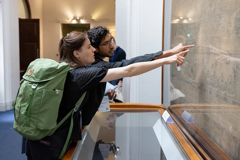 Two conference attendees looking at historic maps at the Royal Geographical Society. 